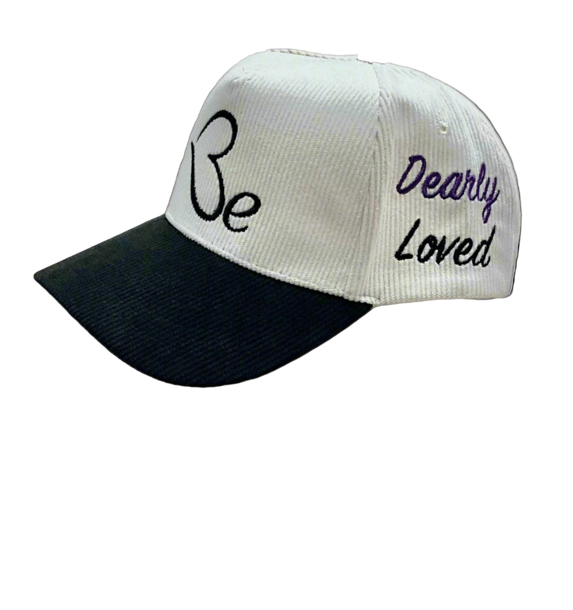 Cream and black cap with the text 'Be' and 'Dearly Loved' embroidered, displayed in side-view.