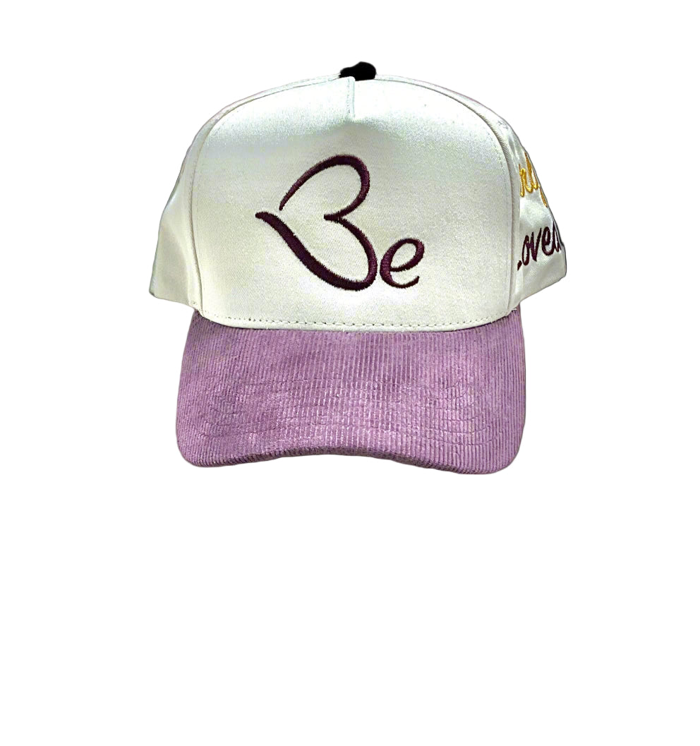 Beloved Cap; Cream/purple cap with 'Be Loved' text on a gray background