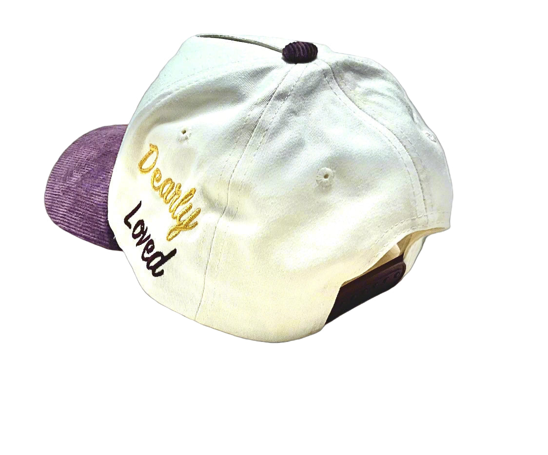Cream cap with 'Dearly Loved' text on a gray background